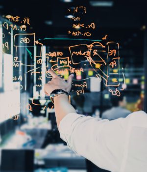 Young businessman standing in front of glass wall thinking and planning concept of work